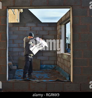 Builder working on home extension project built with block cavity walls. Stock Photo
