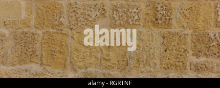 Natural stone background texture, brown beige color. Traditional limestone wall facade background in Malta, banner Stock Photo