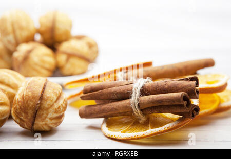 Cookies and slices of orange with cinnamon on a light wooden background, concept of cooking Stock Photo