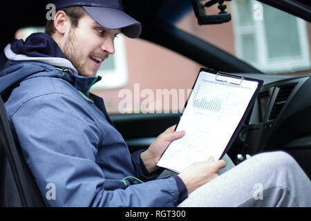 man with documents sitting in the car Stock Photo