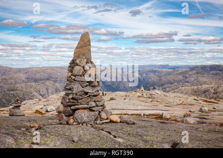 Cairn (a pile of stones) marking mountain hiking trail along the Lysefjord at Kjerag (or Kiragg) Plateau, a popular travel destination in Forsand muni Stock Photo