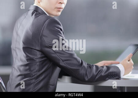 businessman with digital tablet sitting in a cafe near a large window Stock Photo
