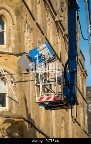 Filming on Location: An Arri 18k HMI fresnel lighting unit , on hire from Panalux film and television lighting company,  suspended from a cherry-picker elevated platform, on a film location , UK Stock Photo