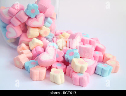 Pink Heart Shaped Marshmallow on the Pile of Pastel Flower Shaped Marshmallow with some in the Glass Jar in Background, Valentine concept Stock Photo