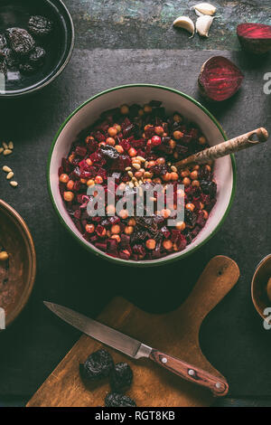 Healthy vegan beetroot salad with chickpeas in bowl on dark kitchen table background, top view. Purple vegetables eating. Clean dieting food. Stock Photo