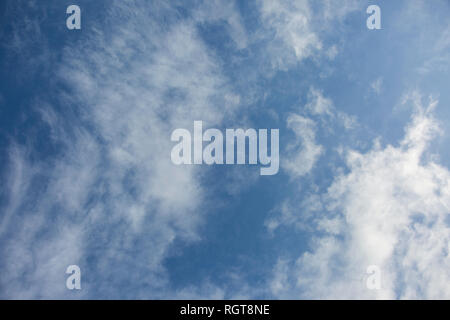 Bright Blue sunny sky with white fluffy clouds floating across on a bright sunny day in England, UK Stock Photo