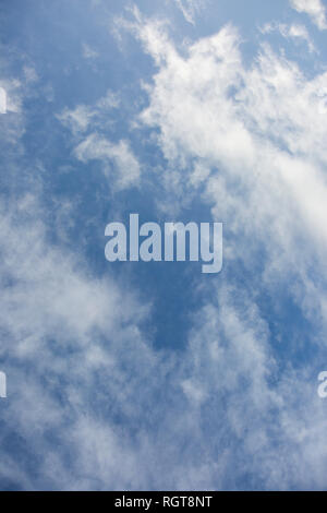 Bright Blue sunny sky with white fluffy clouds floating across on a bright sunny day in England, UK Stock Photo