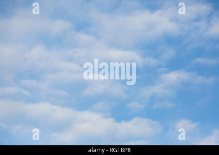 Bright Blue sunny sky with white fluffy clouds floating across on a bright sunny day in England, UK Stock Photo