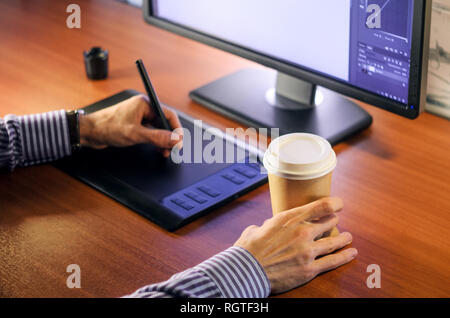 Desktop side view. Computer Graphics Tablet Cup of coffee Hand. Concept for website banner, mockup, background, presentation and marketing material Stock Photo