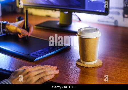 Desktop side view. Computer Graphics Tablet Cup of coffee Hand. Concept for website banner, mockup, background, presentation and marketing material Stock Photo