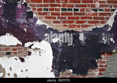 Old Vintage painted Brick and mortar wall with purple plaster and pealing paint, background texture Stock Photo