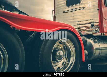 Semi Truck Heavy Duty Tires and Chromed Alloy Wheels. Driving in a Heavy Rain Conditions. Modern Truck Tractor Rear Wheels. Automotive Industry. Stock Photo