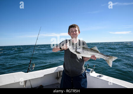 Proud boy with fish caught on deep sea fishing excursion. Stock Photo