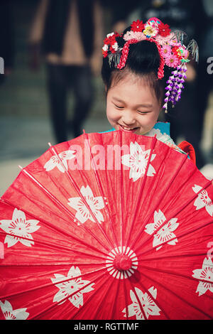 TOKYO, JAPAN - NOVEMBER 28, 2018: Japanese girl with umbrella posing during Shichi-Go-San day at Meiji shrine. Shichi-Go-Sun is annual festival day in Stock Photo