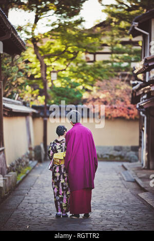 KANAZAWA, JAPAN - NOVEMBER 28: Japanese couple in kimono walking in Nagamachi samurai district. The area preserves samurai residences, earthen walls,  Stock Photo