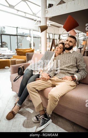 Excellent beautiful couple sitting with wide smiles on their faces Stock Photo