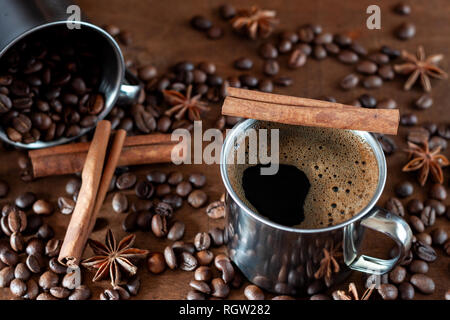 Roasted coffee beans, cinnamon sticks and star anise lie on a wooden table, side view Stock Photo