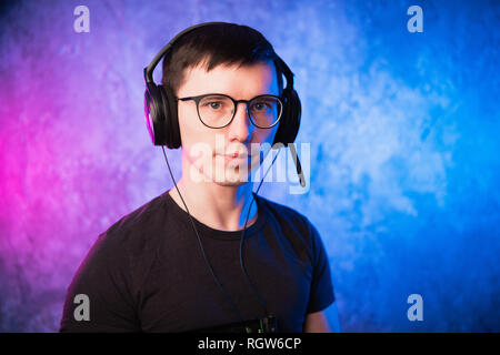 Portrait of a joyful young gamer in headphones. Computer Games Concept Stock Photo