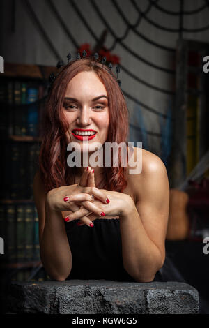 Beautiful young woman in black dress indoor Stock Photo