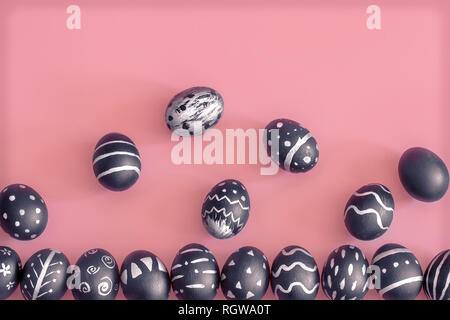 The Easter egg is black with light pattern and creative handmade , colorful pink background , the concept of the Easter holidays Stock Photo