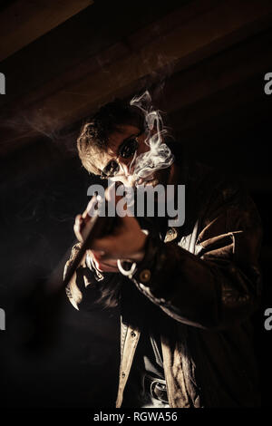 man with shotgun and cigarette Stock Photo
