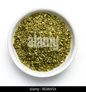 Dried chopped oregano in white ceramic bowl isolated on white from above. Stock Photo