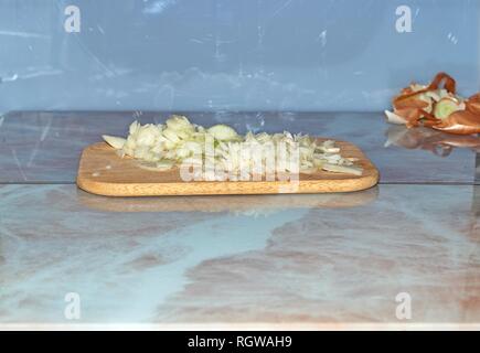 Chef slicing Onion, Allium cepa on the cutting board with a knife. Stock Photo