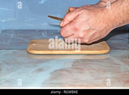 Chef slicing Onion, Allium cepa on the cutting board with a knife. Stock Photo