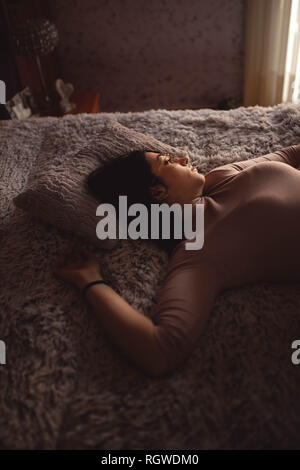 Young Woman lying on bed Stock Photo