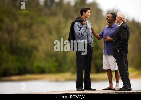 Three men having a discussion on a jetty. Stock Photo