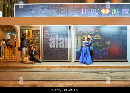 HONG KONG - CIRCA NOVEMBER, 2016: photographer taking shots of couple in Hong Kong at nighttime. Hong Kong  is an autonomous territory on the Pearl Ri Stock Photo