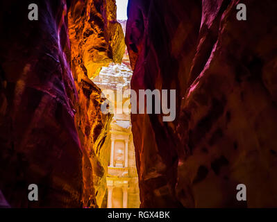 Dramatic view of a narrow canyon passage The Siq leads to The Treasury in Petra Jordan Stock Photo