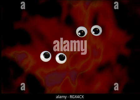 Two pairs of round eyes on dark background. Stock Photo