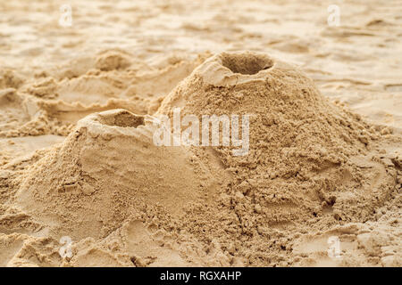 A volcano made of sand on the beach Stock Photo