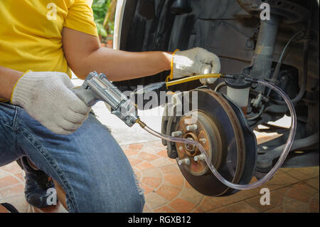Car mechanic bleed air out of brake system Stock Photo - Alamy