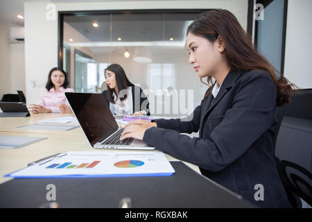 Asian businesswoman serious about the work and using notebook for business partners discussing documents and ideas at meeting Stock Photo