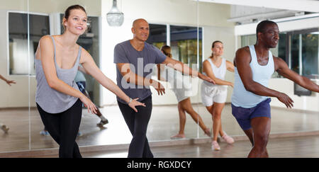 Group of multinational smiling people practicing new dance techniques in modern class Stock Photo