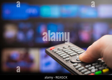TV remote in hand Stock Photo