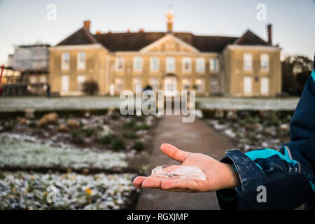 Reigate, UK - January 30, 2019 - a boy holds a peoce of ice in a park; cold weather in the UK January 2019 Stock Photo