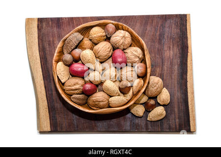 Mixed nuts in wooden bowl on piece of exotic Cola Bola wood Stock Photo