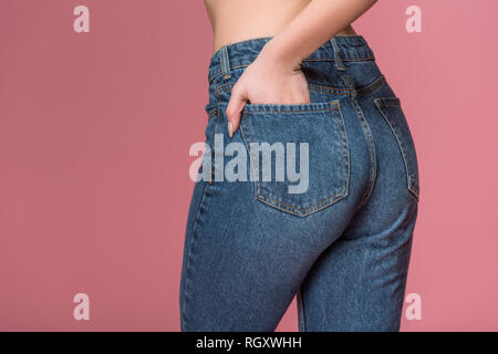 cropped view of female buttocks in jeans, isolated on pink Stock Photo