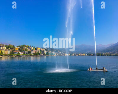Fountain on Alpine Lake Lugano and City in Ticino, Switzerland. Stock Photo