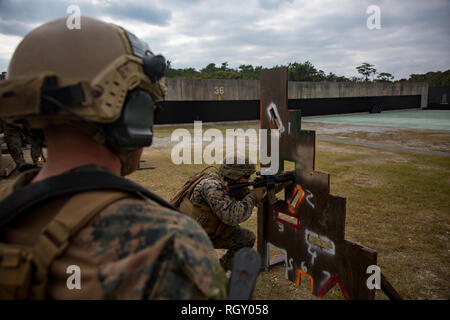 Marines with 3rd Reconnaissance Battalion, 3rd Marine Division, train Marines with 1st Battalion, 3rd Marines, Currently attached to 3rd Marine Division, on live-fire barricade drills on Camp Hansen, Okinawa, Japan, Jan. 29, 2019. The training is designed to improve the unit’s reaction to fire between small openings in walls as well as to improve overall mission readiness. (U.S. Marine Corps photo by Lance Cpl. D’Angelo Yanez) Stock Photo