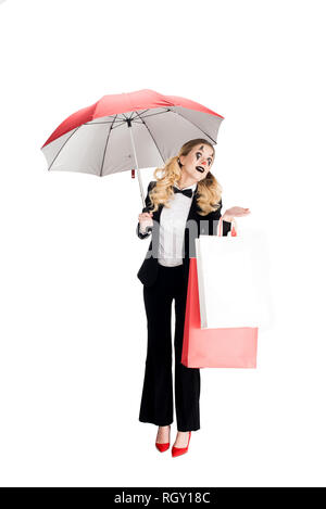 blonde female clown holding shopping bags and umbrella isolated on white Stock Photo