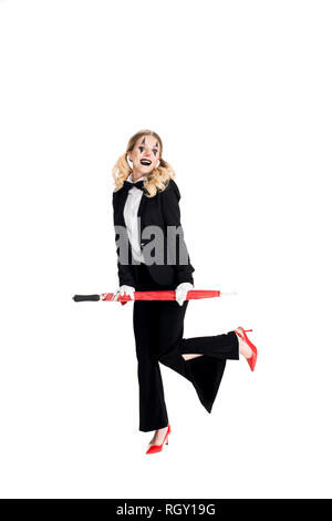 cheerful female clown holding umbrella while standing in suit isolated on white Stock Photo