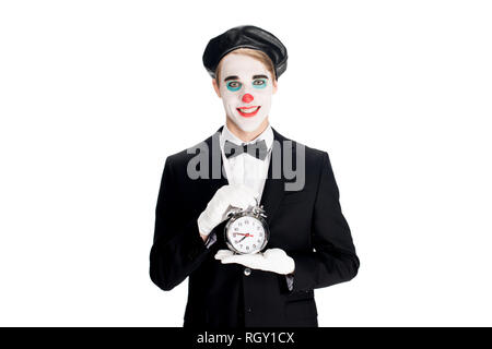 happy clown holding alarm clock in hands isolated on white Stock Photo