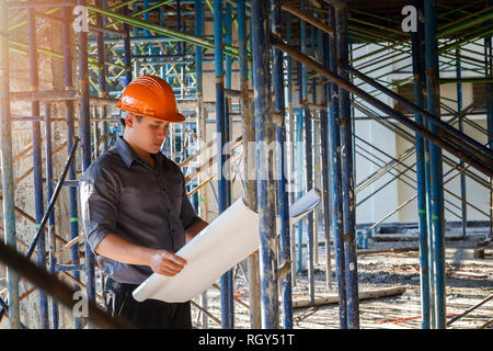 Engineer with blueprint in building construction site Stock Photo