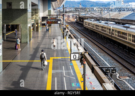 Osaka, Japan - November 21, 2018: Travelers waiting train on platform at Osaka station. Stock Photo