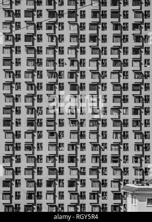 Background texture or wallpaper of outdoor vertical zooming closeup view of multiple layers & floors of a huge high tower condominium with numerous ro Stock Photo