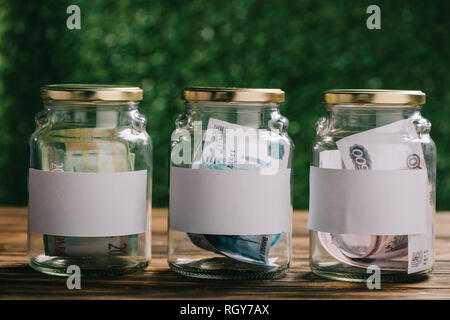 glass jars with blank labels and russian rubles banknotes on wooden table Stock Photo